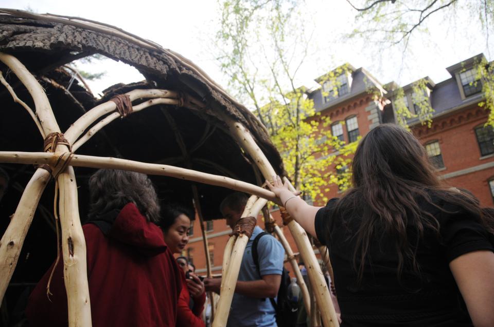 Students enter and explore the wetu, built in honor of the 360th anniversary of the Charter for the Harvard Indian College, in the Yard after its inauguration ceremony yesterday.