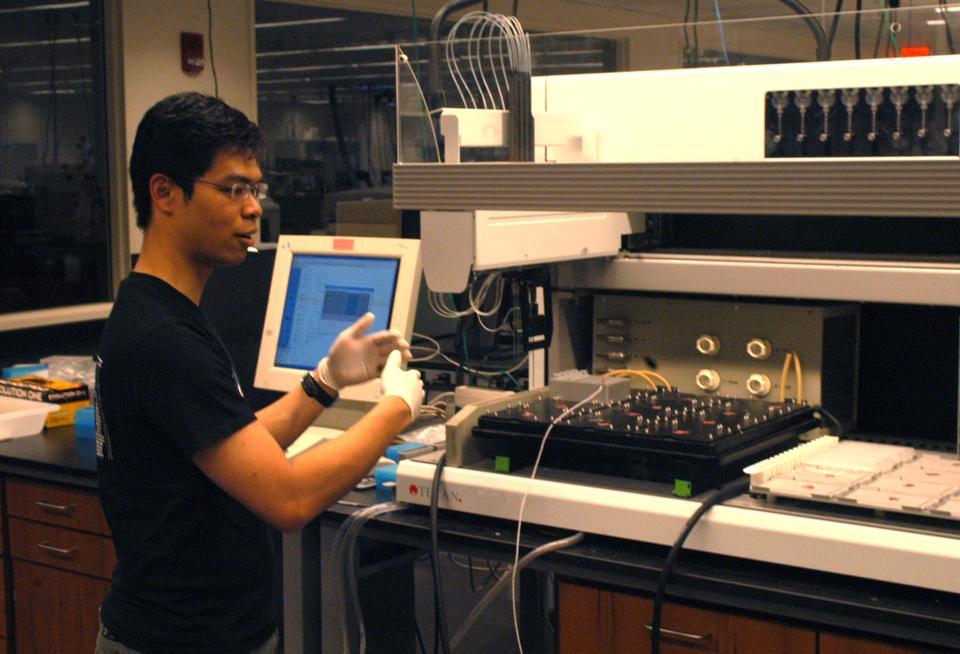 Low shows off the pipetting robot Professor Erin O'Shea's lab, where he has worked since fall semester of his freshman year.
