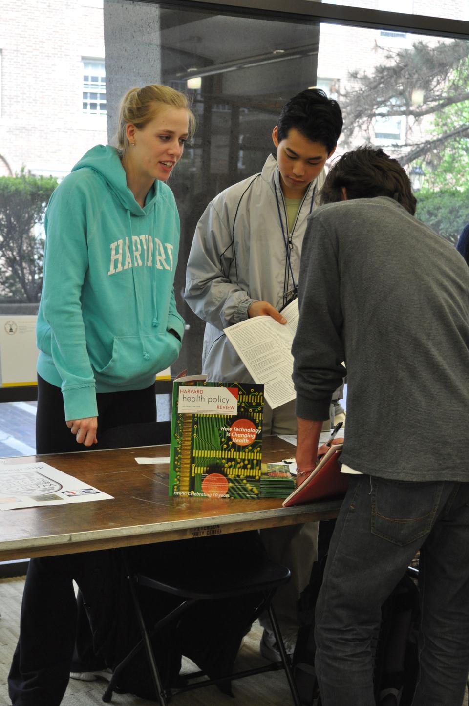 An admitted student adds his name to the Harvard Health Policy Review email list at the Student Activities Fair yesterday, one of many events held for prospective students during this past weekend’s visiting program.