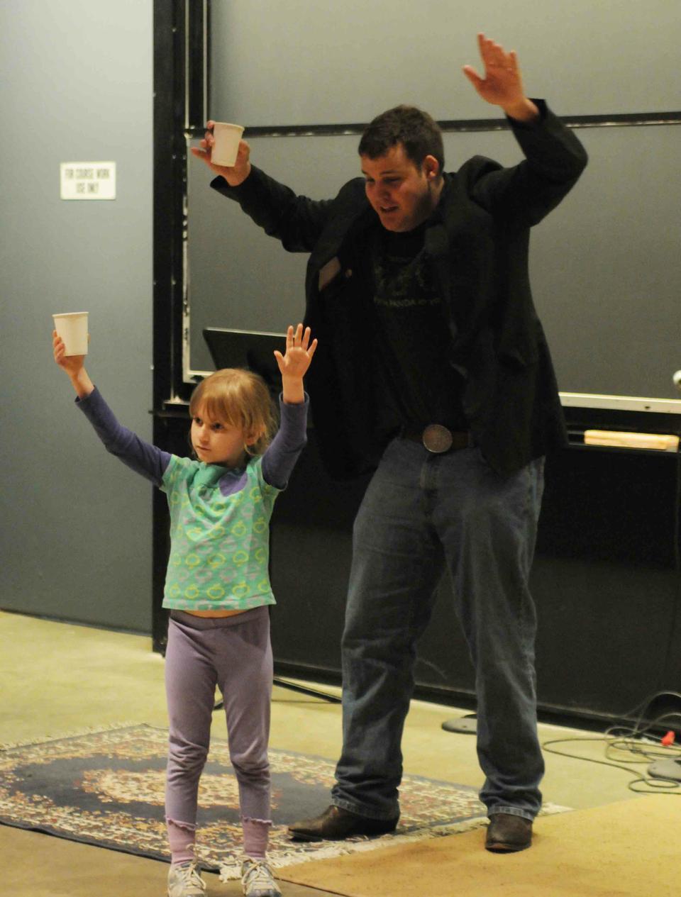 A little girl joins a member of the Harvard Magic Society during a magic show in Science Center C last Saturday, May 1