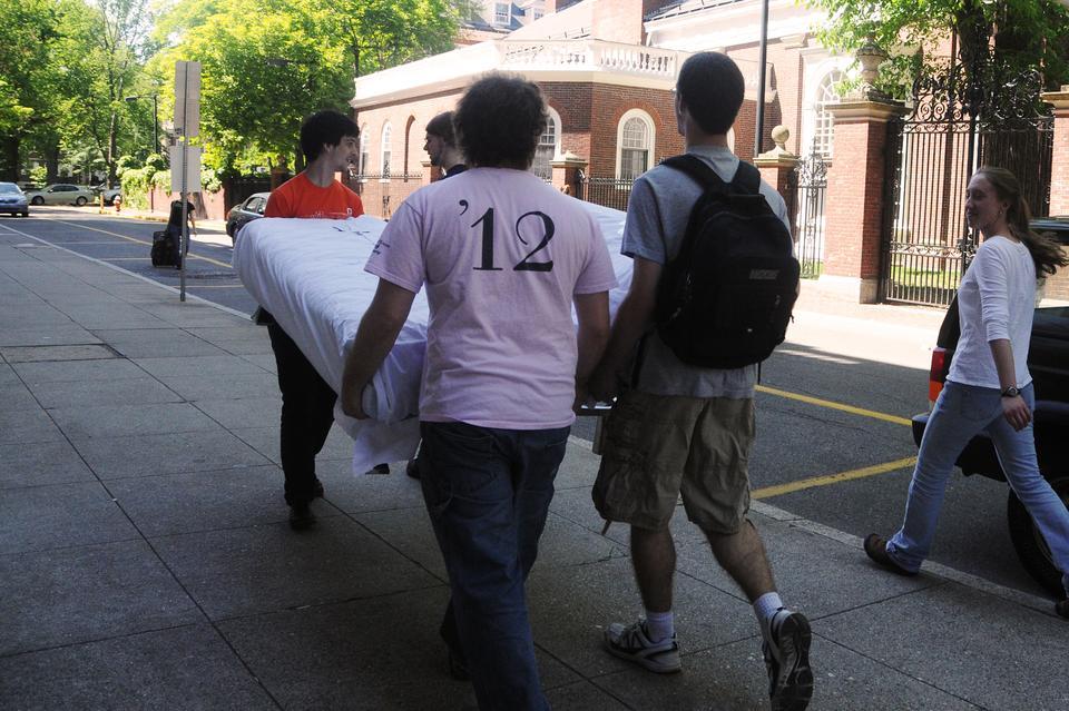 A group of rising juniors moves a mattress into storage yesterday afternoon. College students prepare to leave for the summer as finals' period winds down. 