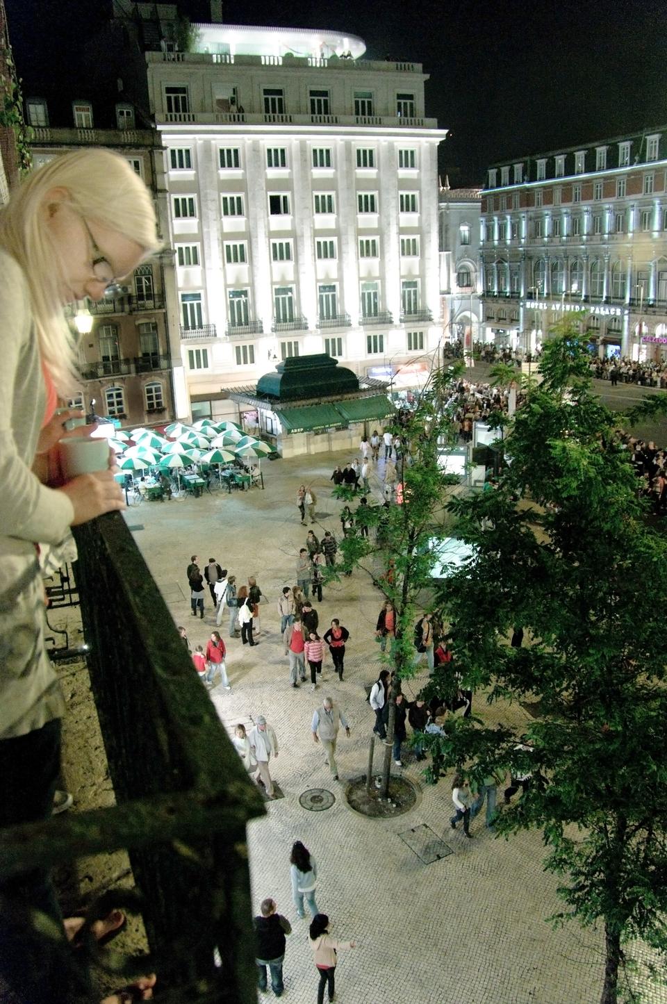 A girl looks out the balcony of her hostel at the tail end of "Marchas Populares",waiting for the parade to cease and the night to begin.