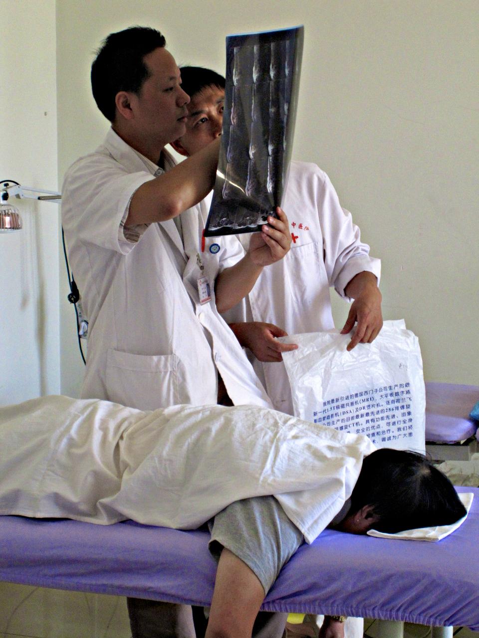 Two doctors at the Yunnan Provincial Hospital of Traditional Chinese Medicine discuss an x-ray to determine what massage methods will be most therapeutic. Crimson photographer Noor M. R. Beckwith '11 is studying Mandarin and traditional Chinese Medicine this summer.