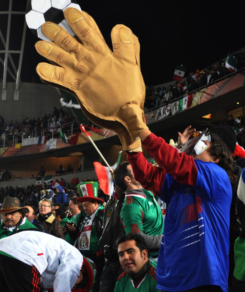 A Mexican fan reminds the French team of "The hand of Henry" which refers to a handball by Theirry Henry in 2009 that was missed by the referee. With this handball, Henry scored the goal that led to his team's aggregate victory during their two-game playoff against Ireland, and accordingly qualified France to the 2010 World Cup. (CORRECTION: An earlier version of this caption incorrectly identified the individual in the picture as a “French fan” cheering for his national team.)