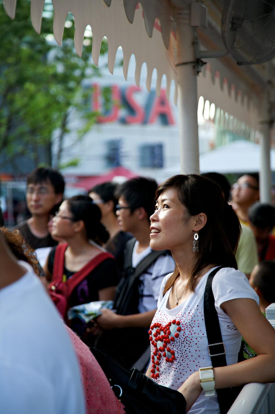 The United States decided to join the Expo very late, so its pavilion is generally not considered to be very impressive. Among other things, it features an American diner—set   up by KFC and Pizza Hut, two popular chains in Shanghai—and videos of President Obama and Hillary Clinton talking about what it means to be American. Here a woman watches an introductory video as she waits in line to enter.