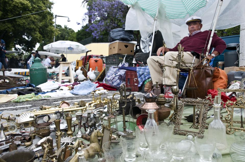 A man watches over his goods  at the Feira da Ladra.