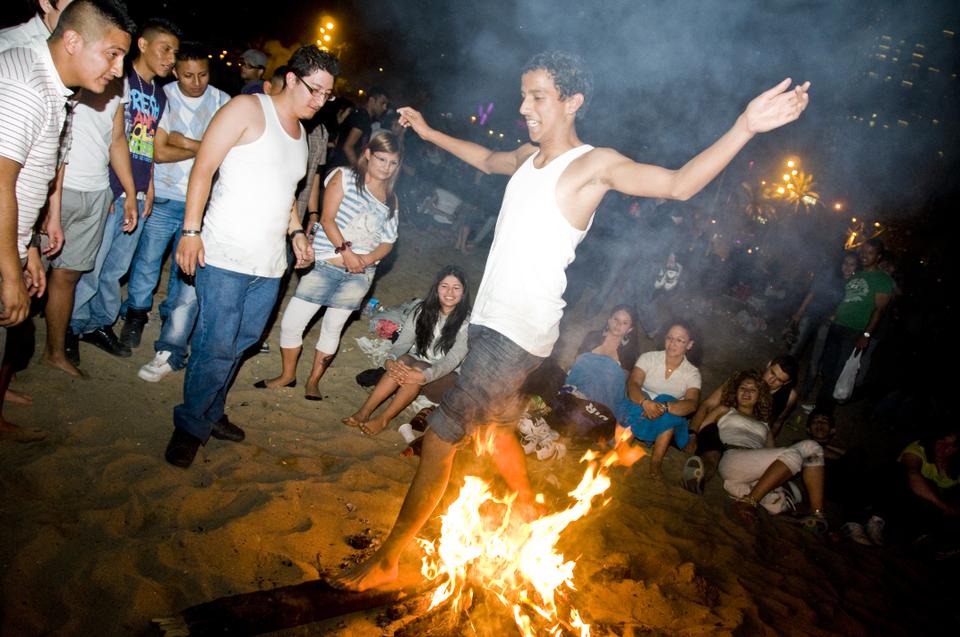 A man walks over the fire in order to fulfill one of the traditions of San Juan, a holiday commemorating the summer solstace.