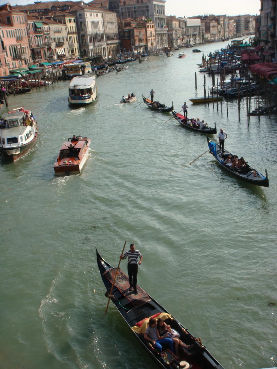 From the Rialto Bridge, one can oversee the Grand Canal and the many boats, vaporetti, and gondolas that travel on its waters. 