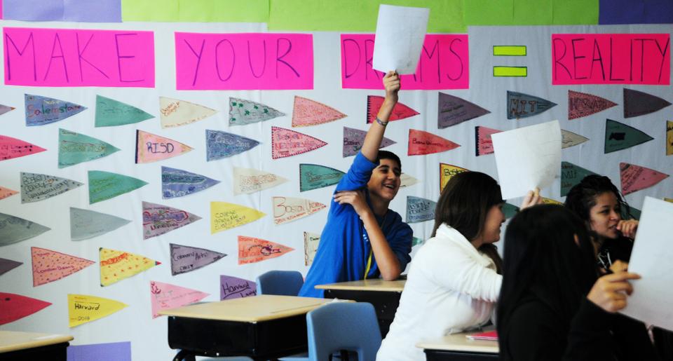 Students eagerly raise their reflection sheets and share the goals they have set for themselves. The flags in the back serve as daily reminders of their dreams; a few wants to attend Harvard.