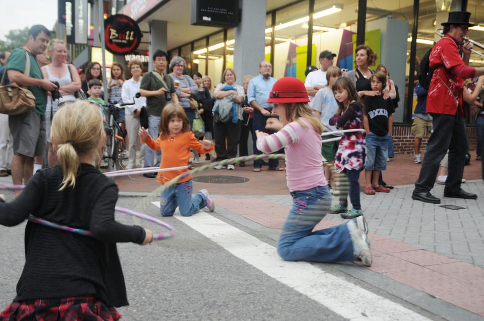 Little girls dance with hula hoops by Harvard Square’s Winthrop Park as part of the Pre-Show Entertainment for the 7th Annual Revels RiverSing, a free celebration of the autumnal equinox by the Weeks Footbridge on the Cambridge side of the Charles River.  