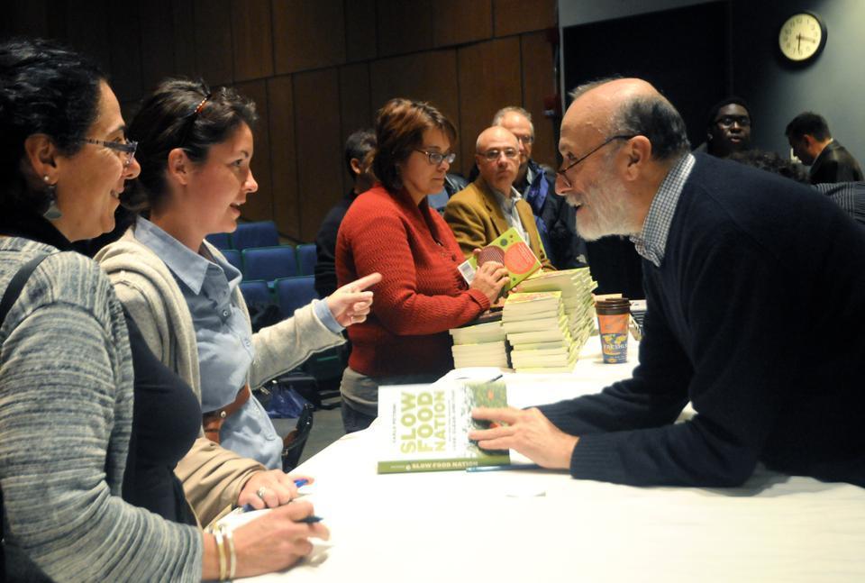 Slow Food Movement founder Carlo Pertini greets audience members and signs copies of his books "Slow Food Nation" and "Terra Madre" at the Science Center yesterday.