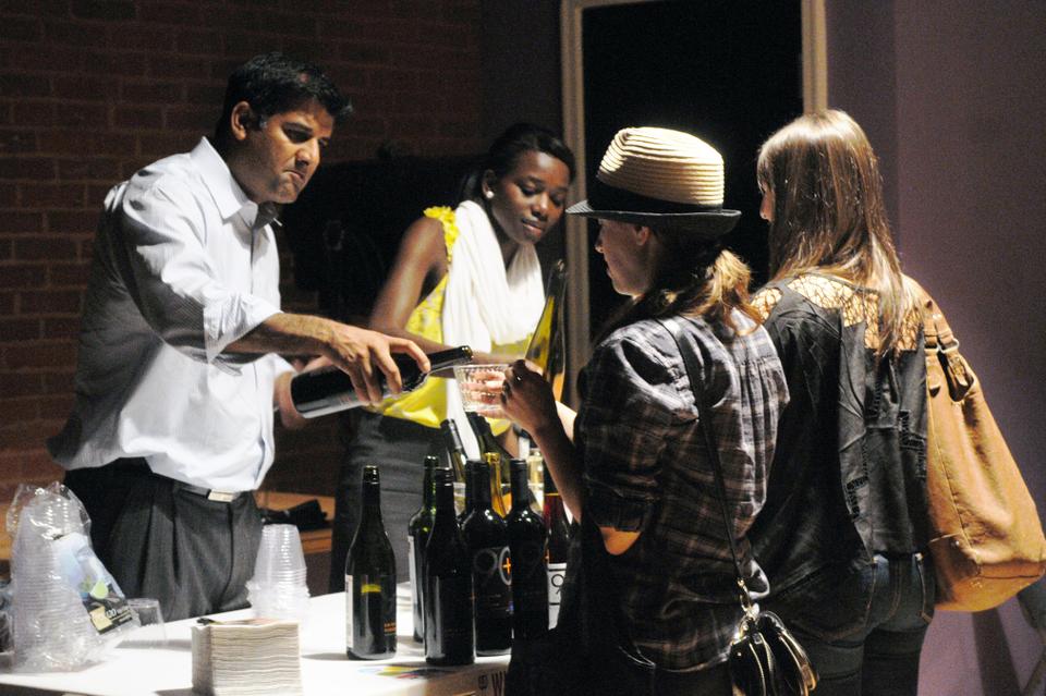 Kevin Mehra and Adjovi Koene of Latitude Beverage Co. serve wine to two shoppers. Second Glass and 90+ Cellars sponsored the event, providing wine and snacks for all attendants.
