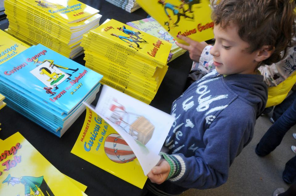 Yoshua Fredkin peruses Curious George books. The festival included many events geared towards children, including seperate family-oriented vendors and workshops.
