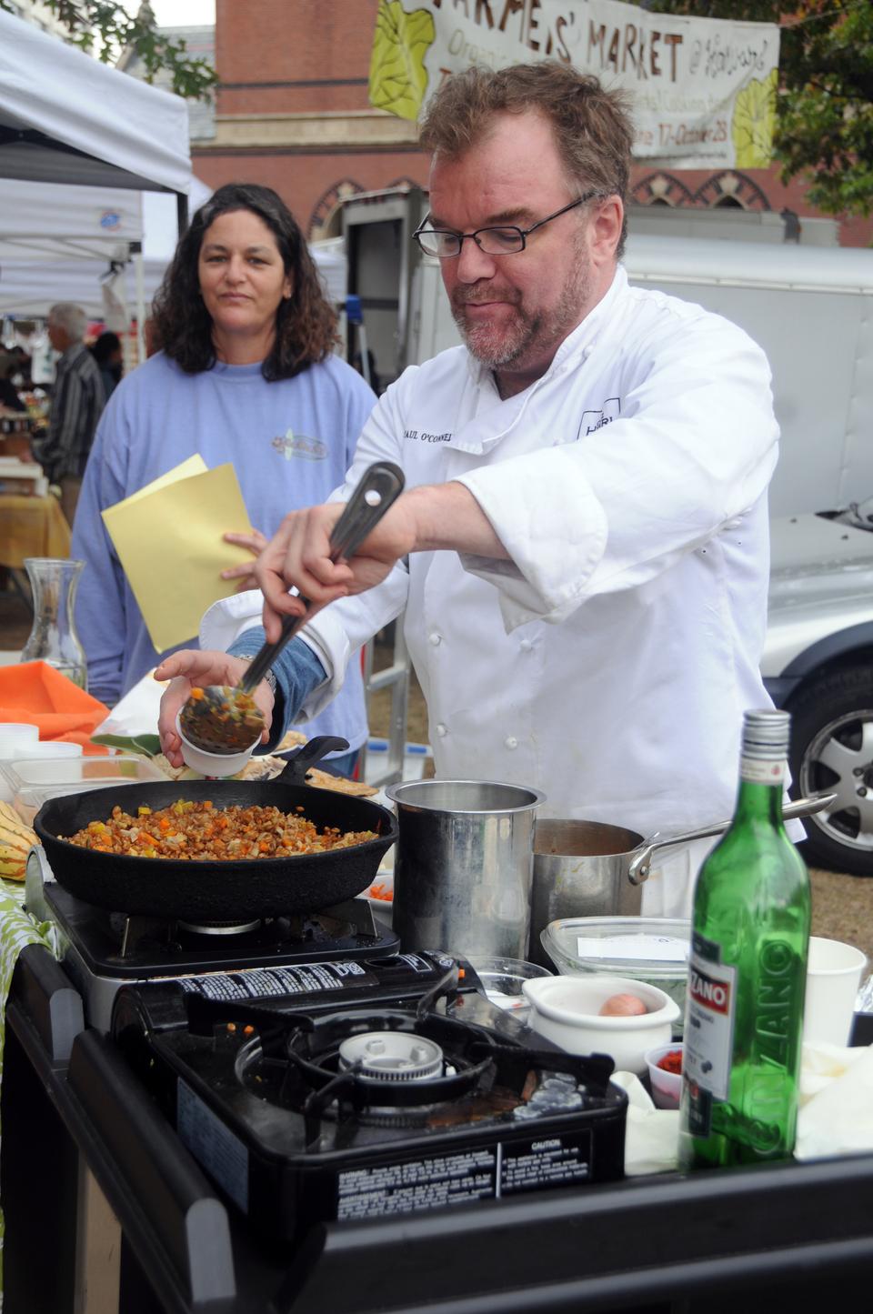 Customers watch local chefs prepare delicacies at the Allston and Harvard's farmers' market. 