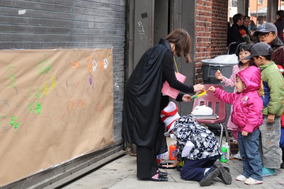 Families enjoy "Halloween at the Coop" Saturday afternoon, where children helped paint a mural, in addition to storytelling, sweet treats, and pumpkin decorating.   