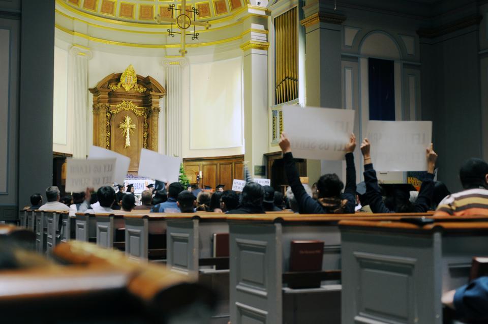 Activists from the Students Immigrant Movement hold up signs that read “LET US LEARN, LET US SERVE” during a rally at the Cathedral Church of St. Paul yesterday afternoon. Students from all around Massachusetts gathered in Boston to partake in a nationally organized effort to support the DREAM Act. 