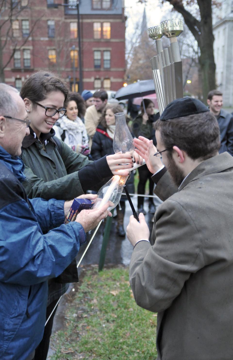Rachel L. Knaster '13, Harvard Chabad Student President, is joined by Rabbi Hirschy and advisor, Prof. Alan M. Dershowitz in welcoming Chanukah with the lighting of candles.