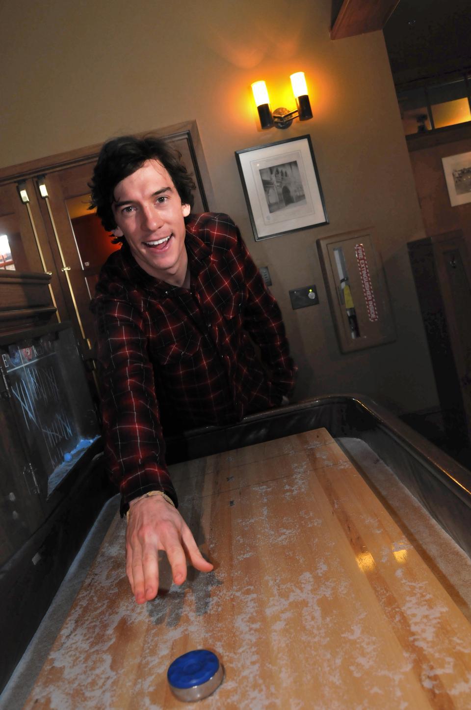 Bowman tries his hand at shuffleboard, another one of his various trades.