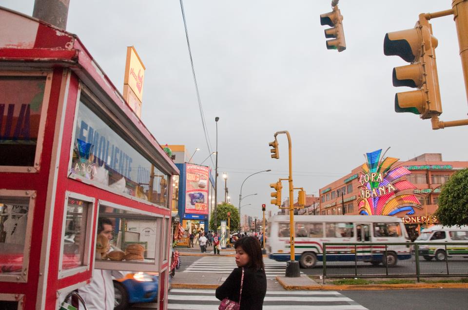 A woman takes a moment to relax before a busy street crossing in the capital city of Lima, Peru.