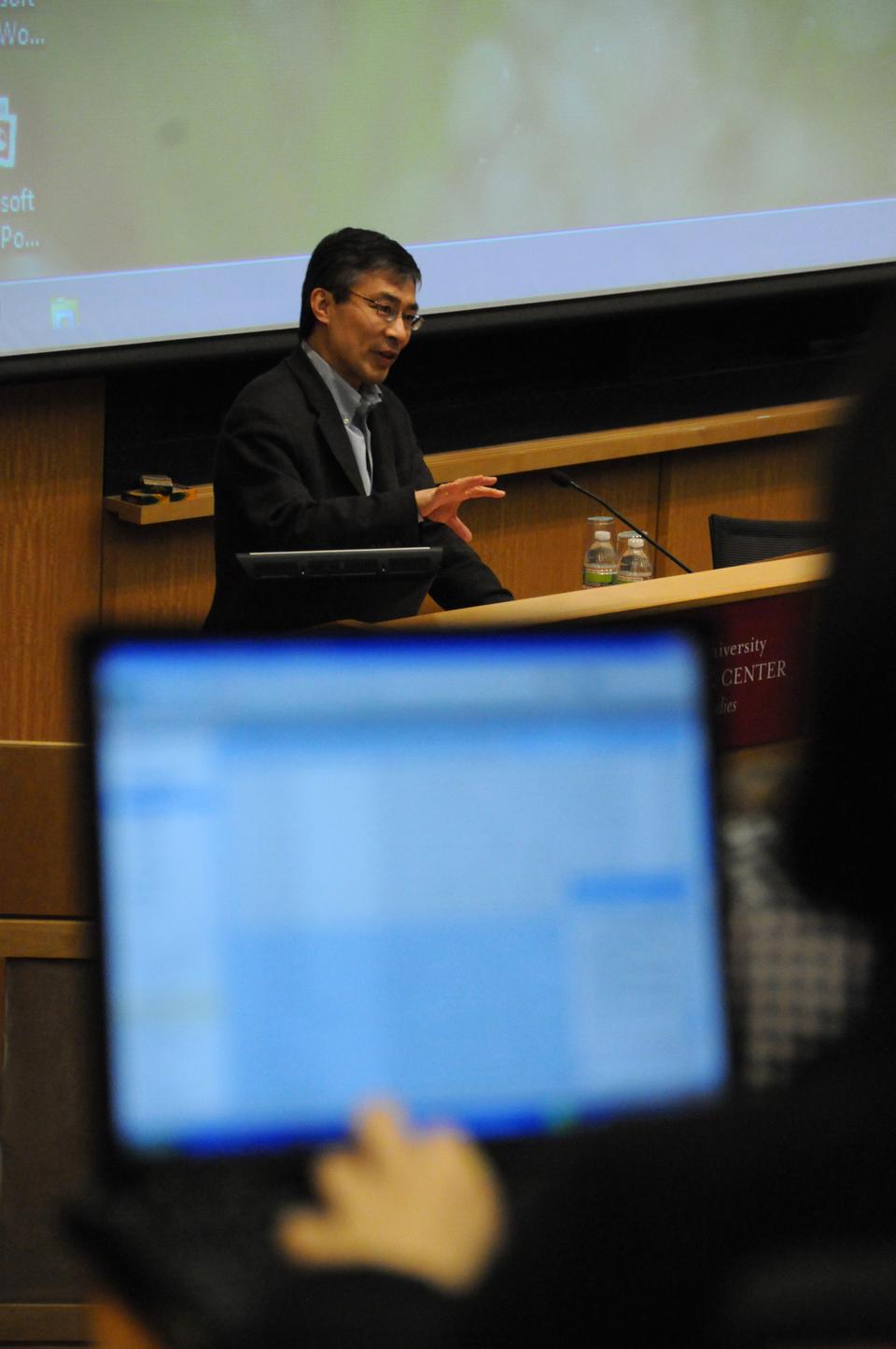 An audience member browses the web as Guobin Yang discusses the patterns of online activism in the decades since 1989 in his presentation, “Twenty Years of Online Activism in China,” at CGIS South yesterday.