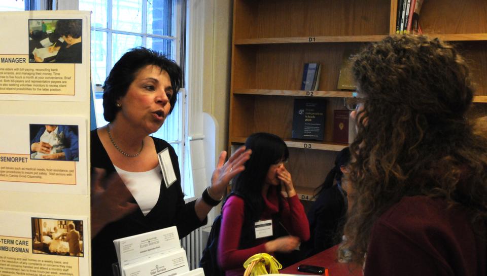 Students investigate and discover ways to become involved at the Clinical Volunteering Opportunities Fair at the Office of Career Services. Marie Mazzeo, Volunteer Programs Coordinator of Somerville Cambridge Elder Services, explains how volunteers are needed to "bridge the gap" between patients and doctors.
