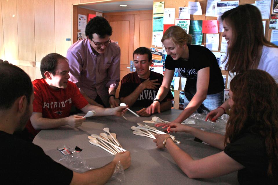 Students and professors team up to discuss the possibilities of using wooden spoons to construct a symmetric design of their own creation.