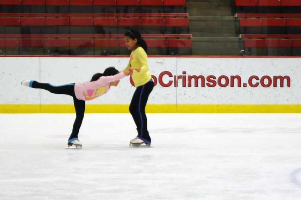Two local children skate together at the 22nd Annual Allston-Brighton Family Skating Party, held at the Bright Hockey Center yesterday. 