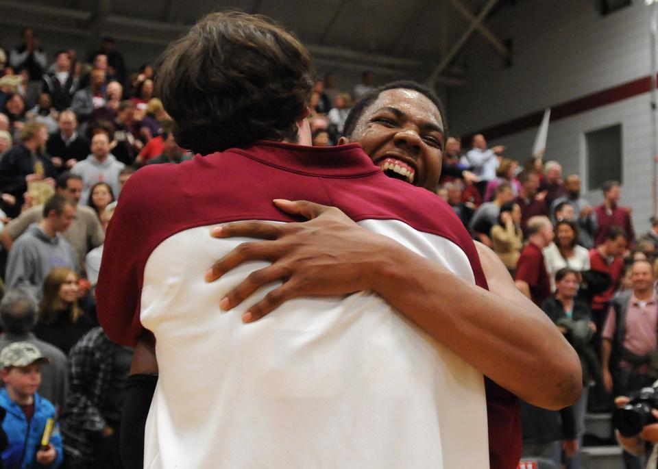 Junior co-captain Keith Wright (right) embraces classmate Andrew Van Nest after the two helped Harvard garner a share of its first-ever Ivy championship in its 100th season of basketball.