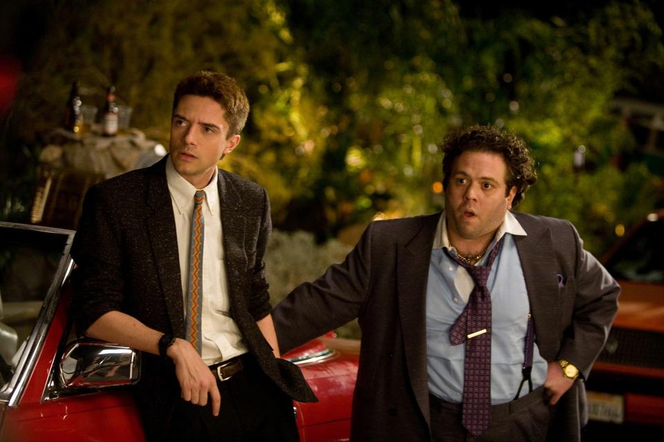 Matt Franklin (Topher Grace) and best friend Barry Nathan (Dan Fogler) survey the scene in “Take Me Home Tonight.”