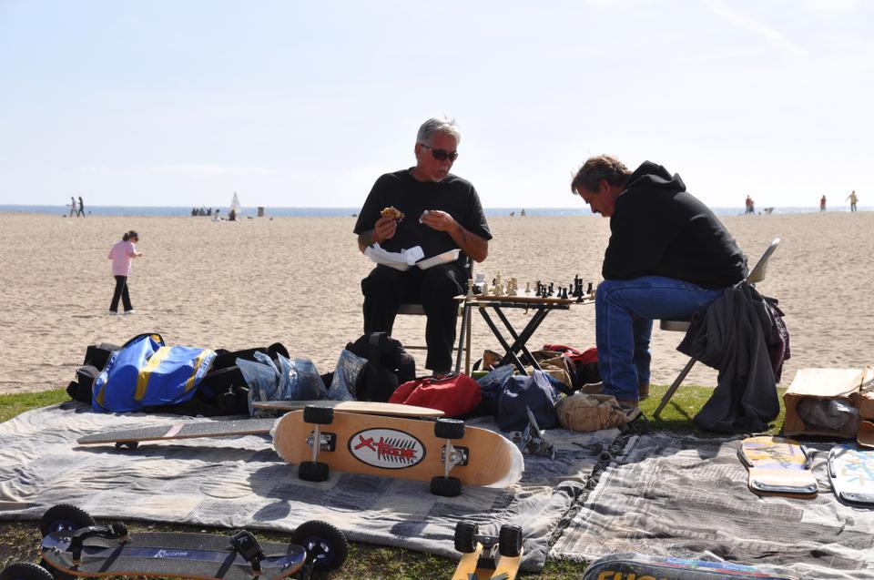 These men, who sell stickers for people to decorate their skateboards with, relax in a mid-afternoon lull to engage in a game of chess.