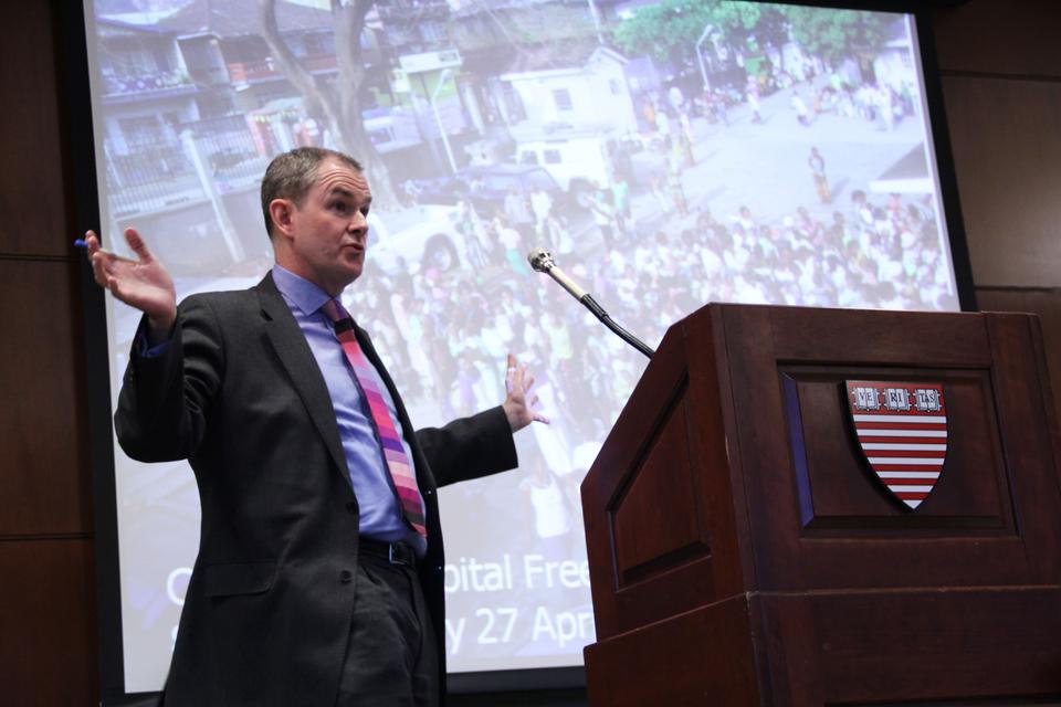 Rob Yates, a British economist and senior health adviser, addresses the audience during a panel on "Health Financing for Universal Coverage" yesterday at the John F. Kennedy School of Government. Here he describes the sudden rush of patients to a hospital in Africa that recently implemented a new healthcare system.