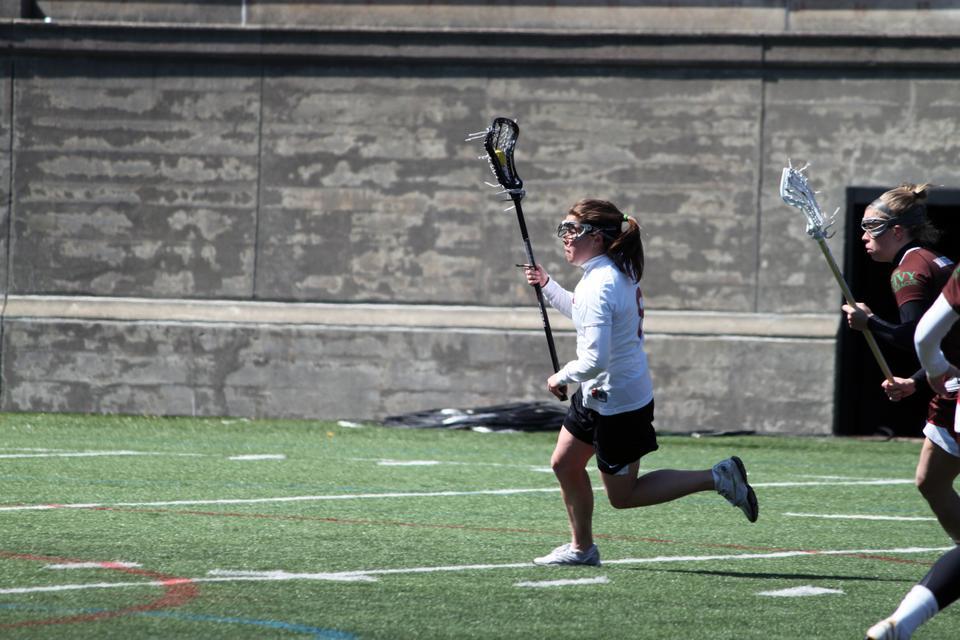 Tri-captain Melanie Baskind, shown here in earlier action, won three draw controls and as many ground balls in Harvard’s win over Holy Cross last night. Two Crimson players—sophomore Danielle Tetreault and classmate Jennifer VanderMuelen—each scored three to help Harvard secure the midweek victory as the team improved to 6-4 on the season. 