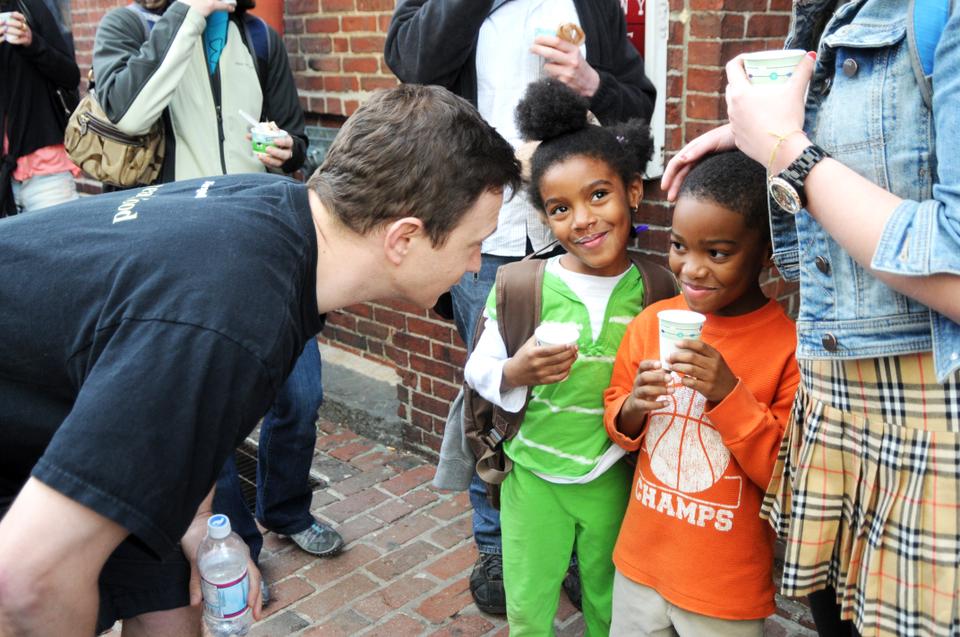 A b.good representee gives milkshakes to two children attending the b.good and Ben & Jerry’s ice cream truck battle Thursday afternoon.  This contest fundraises for the b.good Burger Brigade that is running the Boston Marathon on Monday.