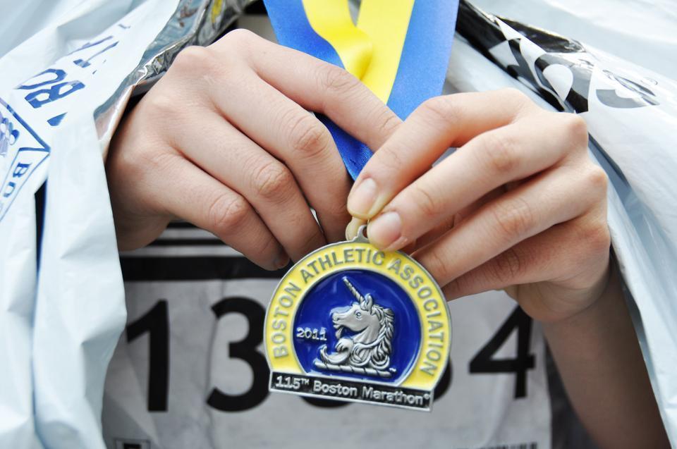 A race-finisher shows off her finisher's medal after completing the grueling 26.2-mile run. 