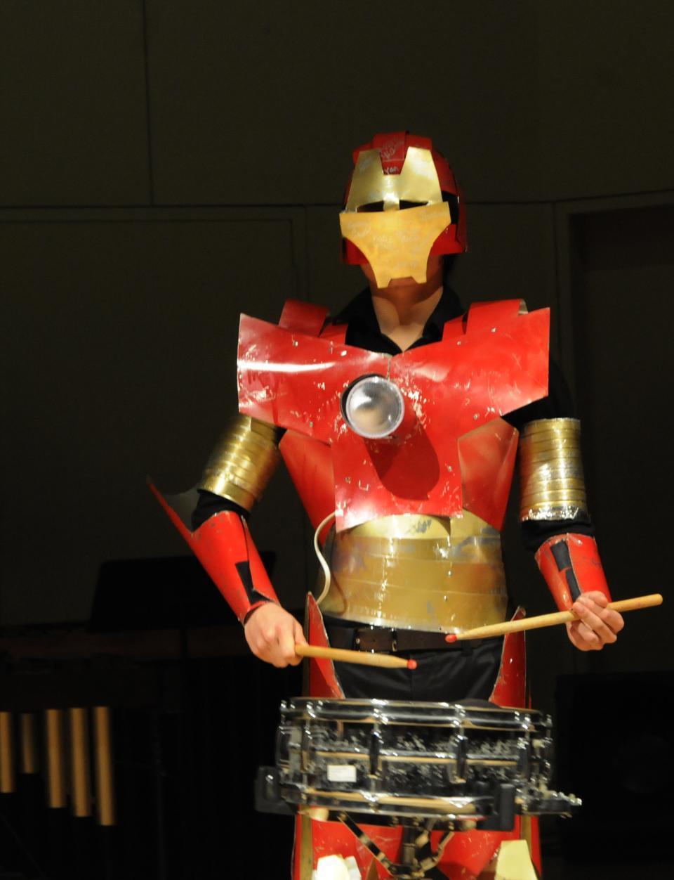 A red robot emerges from the darkness to entertain the crowd in Lowell Lecture Hall during The Harvard Undergraduate Drummers' spring show, THUD Robots. 