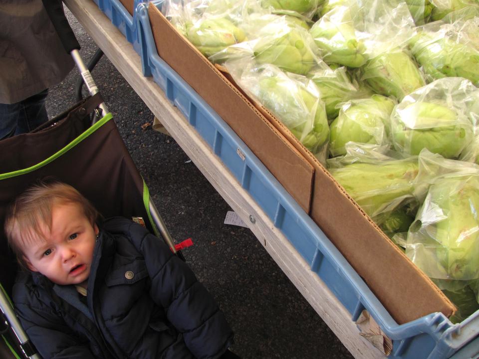 A child cries as his caretaker shops for vegetables among the stands at Haymarket. 