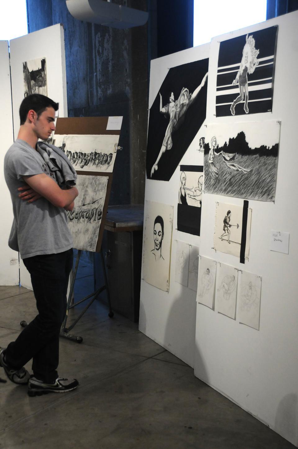 Samuel Rashba '14 admires the artwork of Kyle Rawding '14 on display at the Carpenter Center's Open Studios event, featuring work produced in spring semester art classes on every floor of the building.