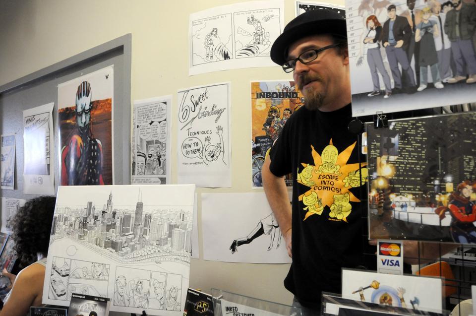 Cartoonist and illustrator Dirk I. Tiede displays illustrations from his Chicago-based graphic novel, "Paradigm Shift," during the Massachusetts Independent Comic Expo.