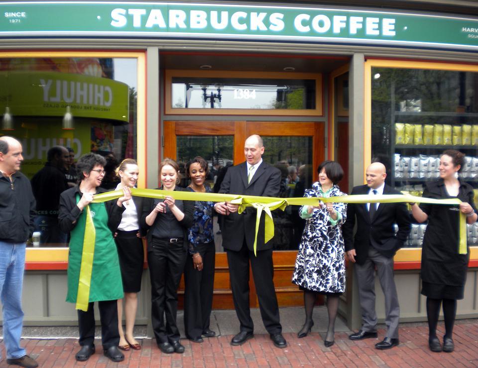 Members of the Cambridge community gather to officially welcome the new two-story Starbucks in Harvard Square on Friday morning. 