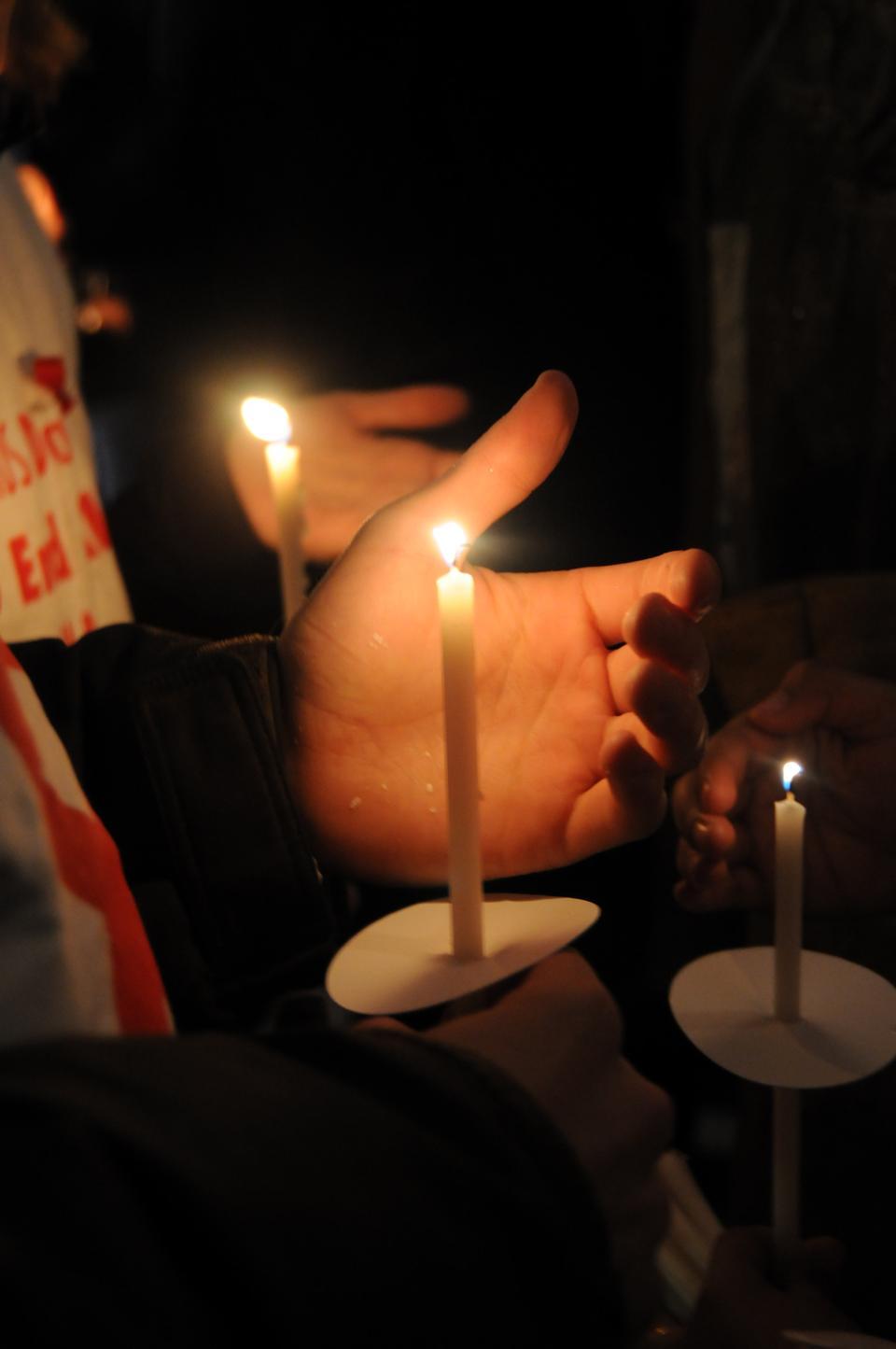Students light candles at a vigil in December to remember the 25 million lives lost to the AIDS epidemic.