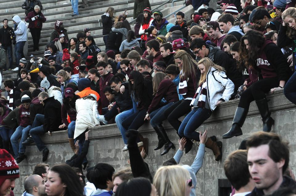 Students jump down from the stands of Harvard Stadium to rush the field after Harvard's win over Yale in the 127th playing of The Game.
