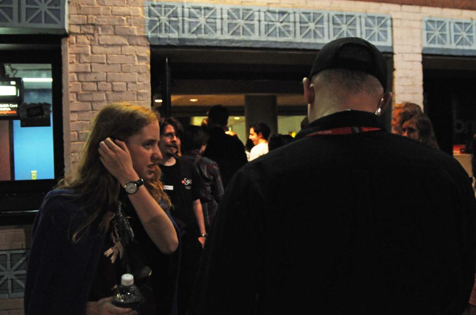 A moviegoer, dressed in magical attire, discusses her Harry Potter ticket with the manager of the AMC Loews Harvard Square theater.