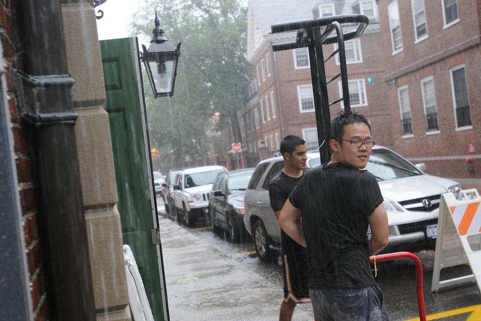 Students move a futon frame out of storage in Leverett House. The rain preceding Hurricane Irene started early in the afternoon on Saturday.
