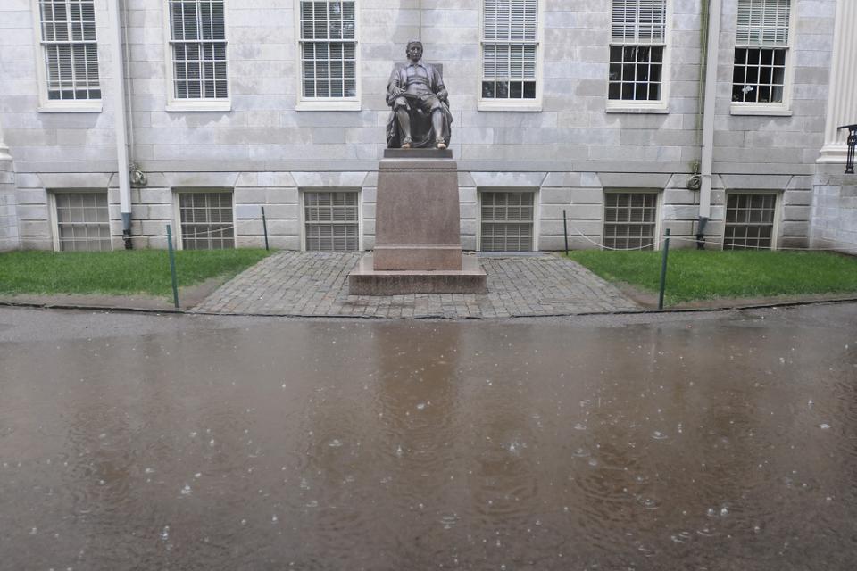 John Harvard presides over an enormous puddle as the usual Saturday tourist crowd fell to a trickle.