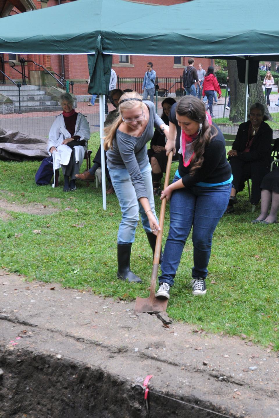 Anastasia M. Walhovd ‘13 and Tia M. Ray ‘12 break the first ground of this semesters archaeology project in Harvard Yard outside Matthews Hall.