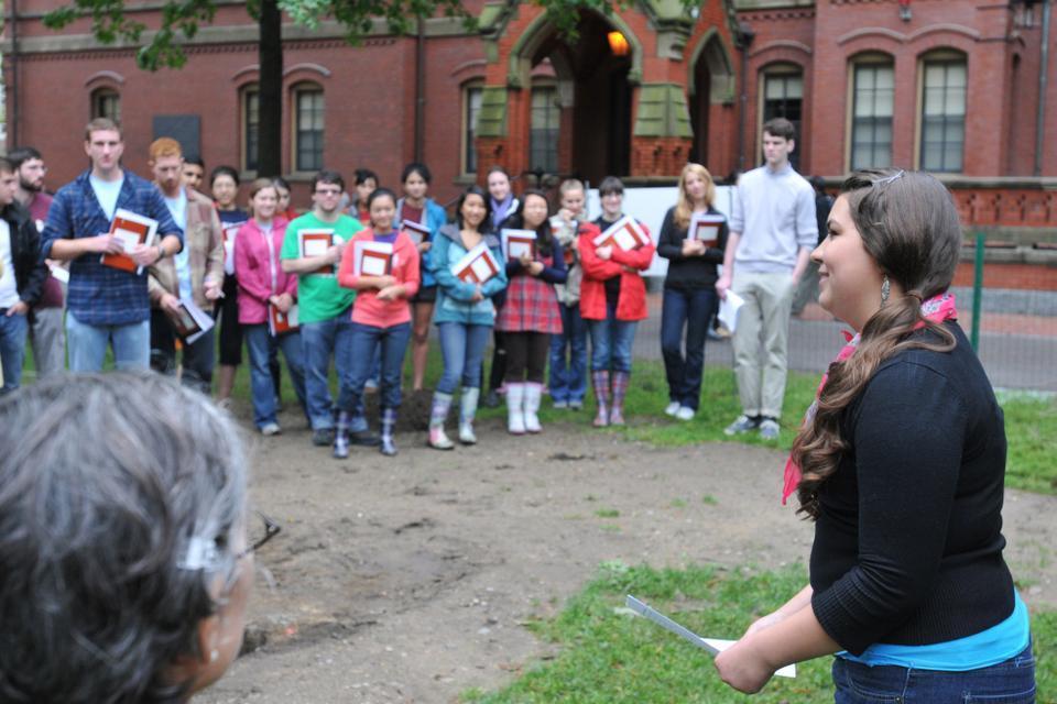 Tia M. Ray '12 discusses the cultural and historic importance of the Harvard Yard Archaeology Project this year's participants and guests outside Matthews Hall yesterday.