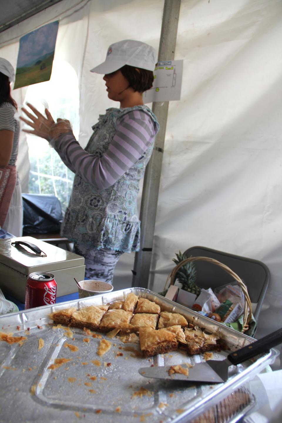  A young girl sells a traditional Serbian dessert called Baklava.  This common household favorite is made with dough, walnuts, and sweetening, usually in the form of honey.