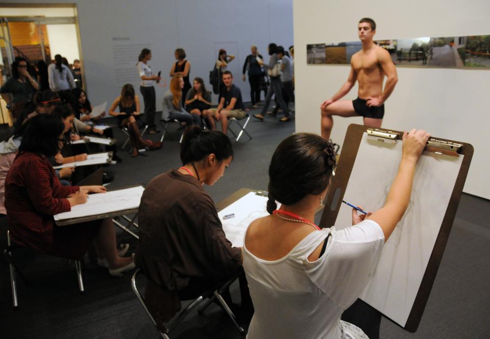 Students practice their art skills sketching a model during the "Drawing in the Galleries" segment of the program.