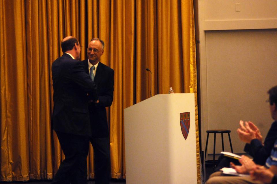 Harvard Business School lecturer Nicolas P. Retsinas (right) greets Habitat for Humanity CEO Jonathan Reckford before Reckford's address on affordable housing at the Harvard Graduate School of Design.