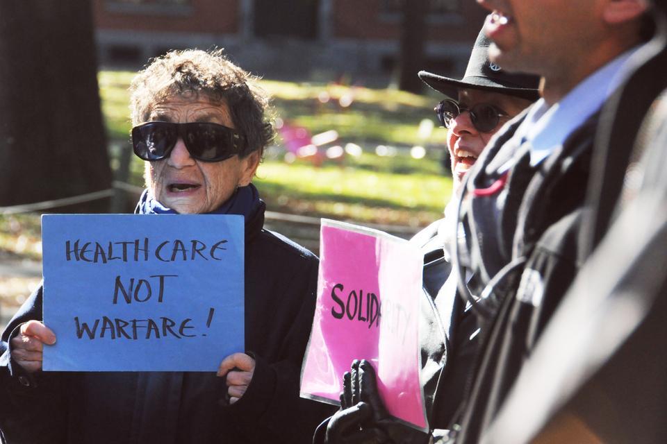 Dorothy Manasiam (left) and Jane Collins (right), part of a group that weekly does a Harvard-Cambridge Walk for Peace, joined the protest in front of John Harvard statue.
